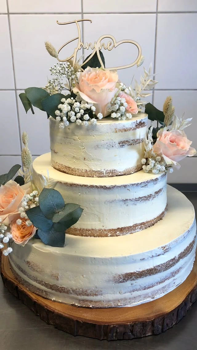 Dreistöckige Hochzeitstorte in Naturtönen mit Kraftpapier-Optik, Pfirsichrosen und Herz-Topper von der Landbäckerei Friedrich