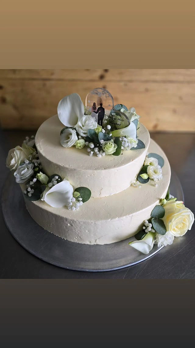 Dreistöckige Hochzeitstorte in Weiß mit Calla-Lilien, Rosen, Eukalyptus und Brautpaar-Topper