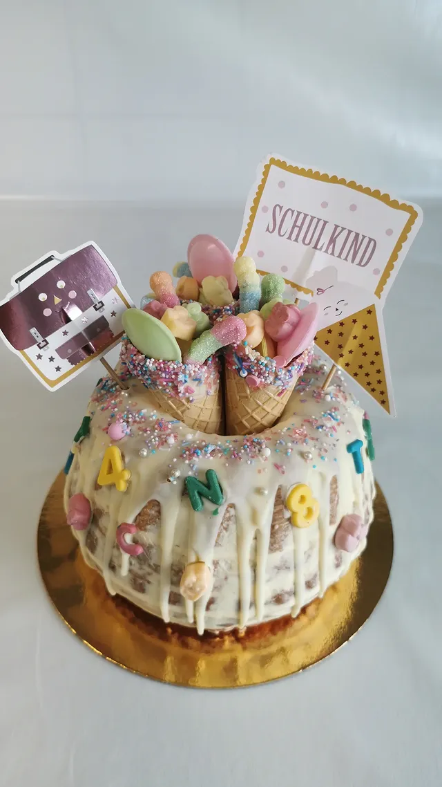Bunte Schulanfangstorte mit Schulkind-Figur, Eis und Zahlen