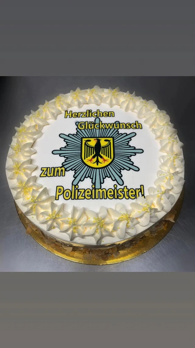 Runde Sahnetorte in Gelb mit Glückwunsch zum Polizeimeister
